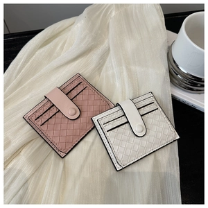 Detail of woven texture card holders in pink and white with secure snap closure