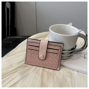 Detailed view of pink woven card holder with multiple slots on a soft white background