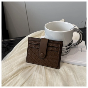 Detail of a brown woven leather card holder with secure snap button and multi-card slots