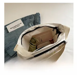 Vue intérieure d'un sac bandoulière en nylon blanc montrant le rangement du portefeuille