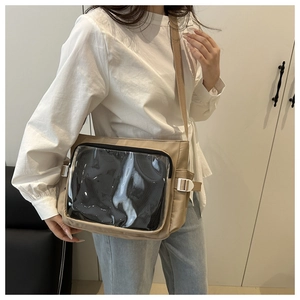 Detail of khaki ita-bag with clear PVC window and adjustable buckle strap on person