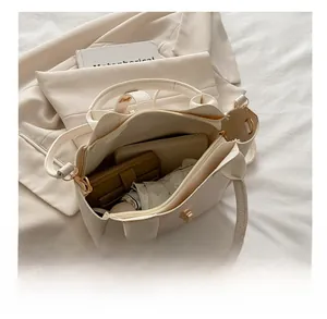 Top-down view of spacious interior of cream leather bucket bag with daily essentials
