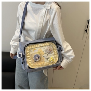 Blue itabag detail with clear PVC window showcasing anime badges and yellow ruffle trim