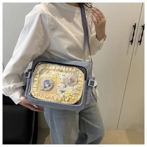 Detail view of the transparent PVC window on the light blue Ita-bag with anime pins