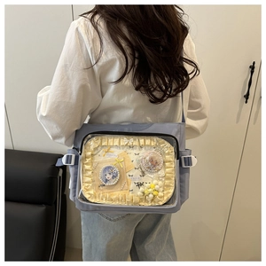 Vue détaillée d'un sac cabas en toile bleu clair avec fenêtre PVC et badges de dessins animés