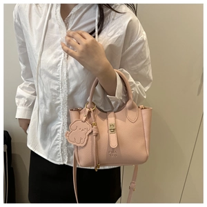 Pink lychee texture leather tote bag detail with cute dog charm and PNA TRO logo