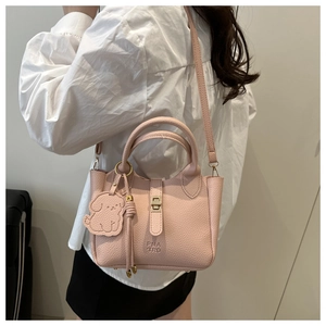 Pink lychee grain leather tote bag with dog charm and twist lock detail on model
