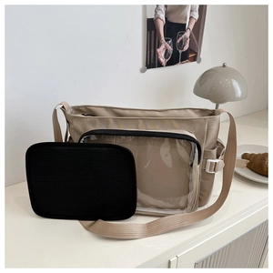 Détail du sac à bandoulière en nylon beige avec compartiment transparent et pochette noire