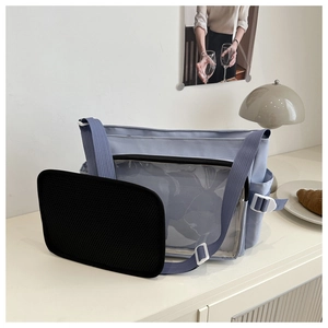 Sac bandoulière bleu clair avec poche avant transparente dans un décor de café doux