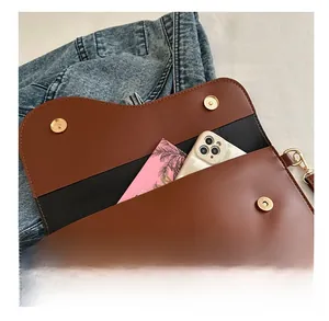 Interior view of brown leather envelope bag showing storage capacity for phone and booklet