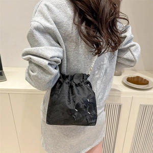 Elegante schwarze Schmetterlingsbeuteltasche mit Perlenriemen für Damen in moderner Umgebung