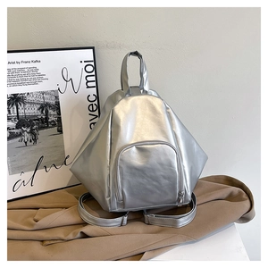 Détail d'un sac à dos géométrique argenté avec finition métallique et poignée supérieure