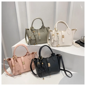 Close-up of litchi grain leather bucket bags in gray, white, pink, and black with gold buckles