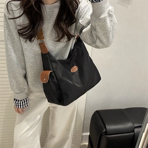 Classic black nylon hobo tote bag with brown leather straps and spacious interior