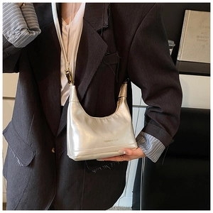 Silver metallic dumpling bag worn by model with FASHION & BAGS branding details