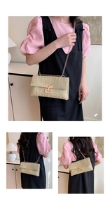 Detail of beige straw woven crossbody bag with gold chain and metal clasp on model