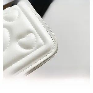 Detailed view of white PU leather texture with elegant heart pattern quilting and fine stitching