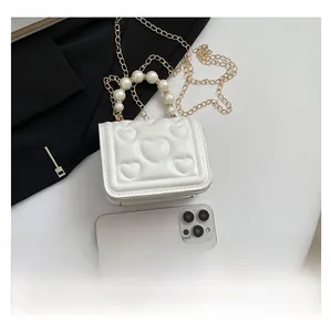 Detailed comparison showing the mini white heart quilted bag next to a smartphone