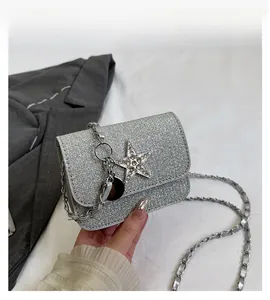 Detail of silver sequin crossbody bag with star rhinestone charm and chain strap