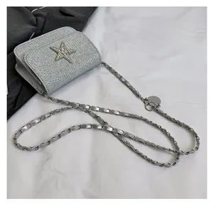 Detail of silver sequin crossbody bag with rhinestone star and chain shoulder strap