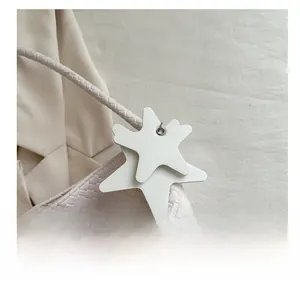 Détail du sac à main tissé avec pendentif en étoile et poignée tressée élégante