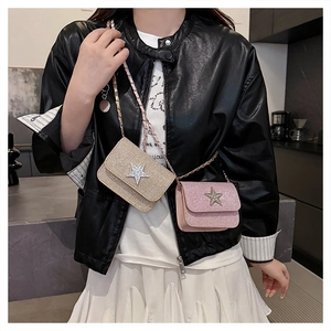 Dettaglio della mini borsa a catena con stella di strass e tessuto glitter rosa e oro