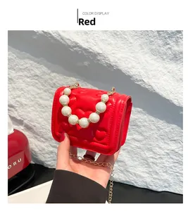 Detail of red heart quilted mini bag featuring large pearl handle and gold chain strap