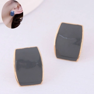 Détail de boucles d'oreilles clips rectangulaires en résine grise avec bordure dorée