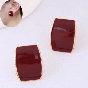 Détail macro de boucles d'oreilles clips en émail rouge foncé avec bordure dorée