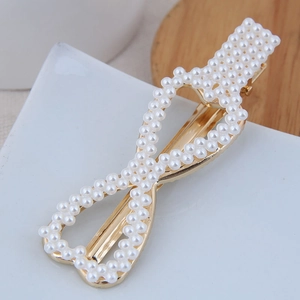 Vue détaillée d'une barrette élégante en forme d'infini avec perles et base dorée chic