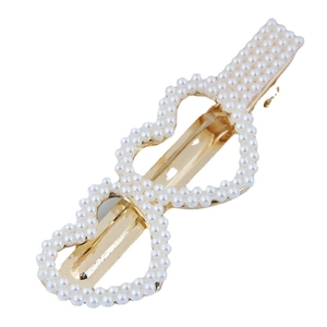 Barrette dorée élégante avec design double cœur et perles blanches sur fond blanc pur