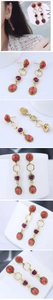 Détail de boucles d'oreilles vintage avec pierres rouges et violettes et finition or antique