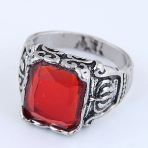 Macro shot of square red stone and vintage silver carved pattern on gothic claw ring