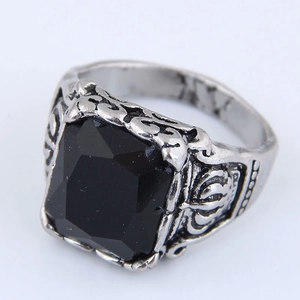 Macro shot of vintage silver ring with large square black gemstone and ornate carvings