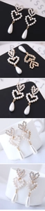 Macro shot of gold-plated double heart earrings with white pearls and sparkling crystals