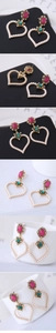 Macro detail of heart drop earrings featuring pink resin gems and white faux pearls