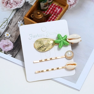 Dreiteiliges Haarspangen-Set mit goldenen Seesternen, Muscheln und Perlen auf Karte