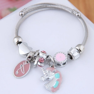 Detail of silver unicorn charm bracelet with pink enamel, love tag and crystal beads
