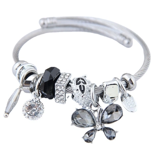Silver charm bracelet with crystal butterfly pendants and zircon beads on white background