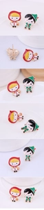Macro view of cartoon girl and boy mismatched stud earrings with golden finish