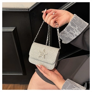 Dettaglio della mini borsa a patta in paillettes argento con stella di strass