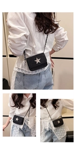 Detail view of mini black sequin crossbody bag with silver star and chain strap on model