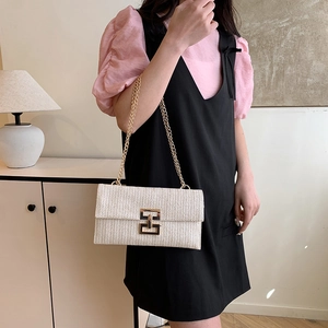 Pochette bohème tissée avec chaîne dorée et texture en V portée par un mannequin