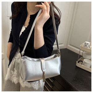 Detail of silver metallic PU shoulder bag with slim strap and vertical metal pendant