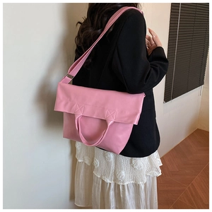Model wearing a large pink soft leather tote bag showing crossbody side view and texture