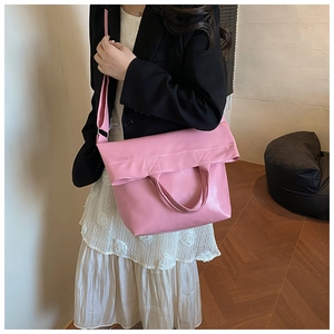 Close-up of pink PU leather tote bag with square stitching worn by model