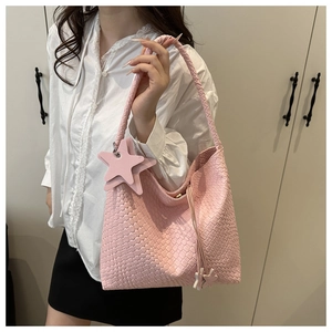Vue détaillée du cabas tressé rose avec texture en similicuir et breloque étoile