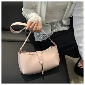 Detail of the elegant light pink shoulder bag with a sleek metallic gold accent