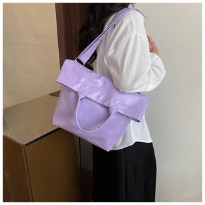 Rear view of a person carrying a lavender faux leather tote bag with crossbody strap