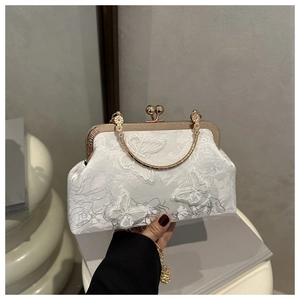 Detail of white satin handbag with floral lace and delicate 3D butterfly embroidery